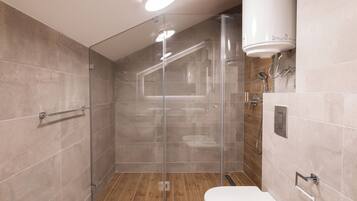 A modern bathroom with a glass-enclosed shower, a toilet, and a sink.