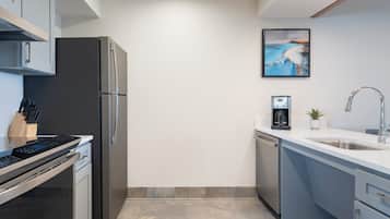 A modern kitchen with stainless steel appliances, a dishwasher, and a coffee machine.