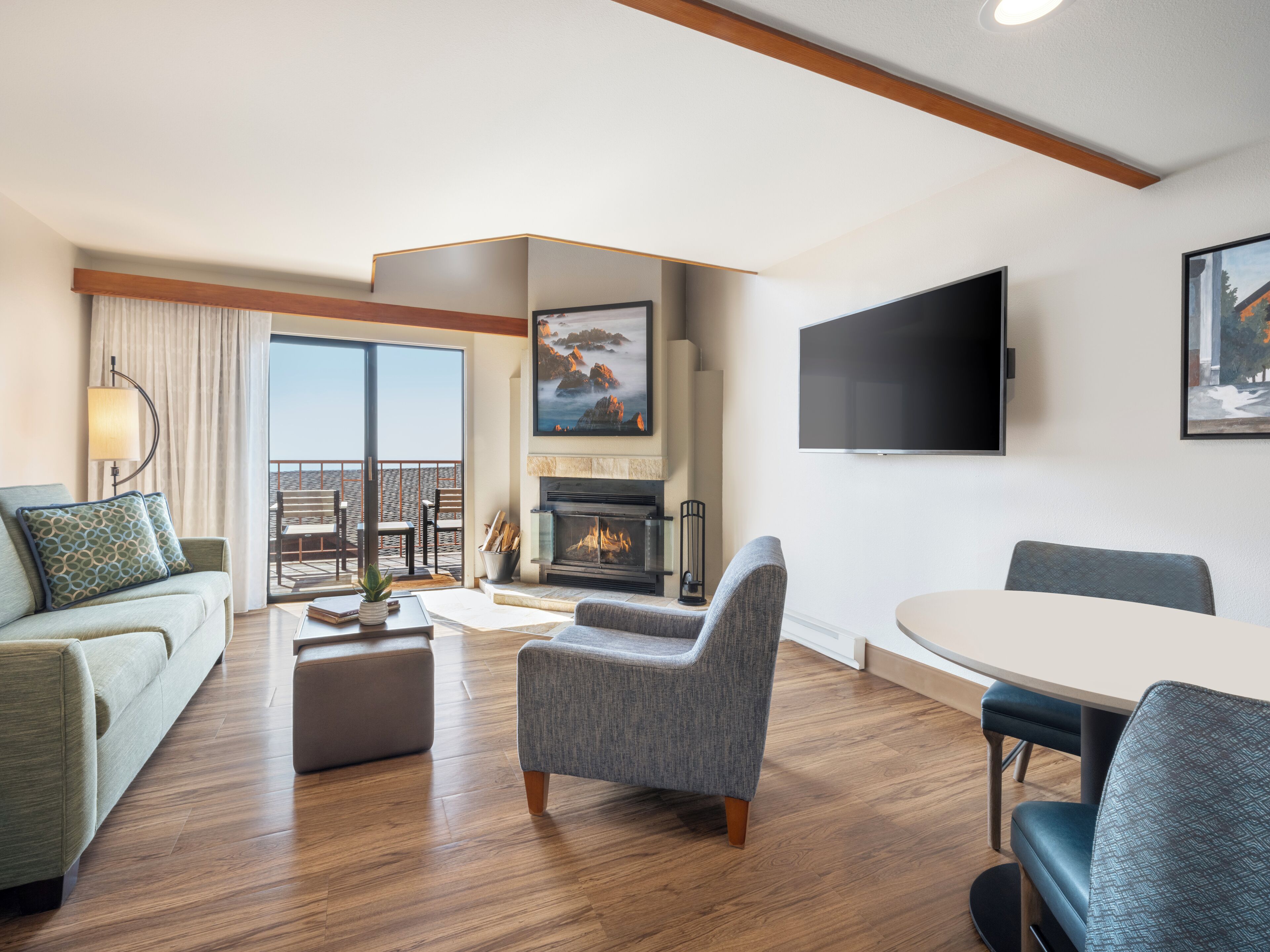 Una sala de estar moderna con chimenea, un televisor de pantalla plana y un balcón con vistas.
