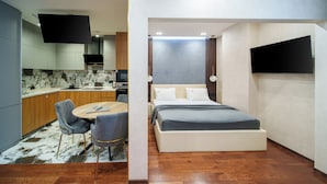 A modern hotel room with a bed, bedside table, and a small seating area with a chair and table. - Arch Apart Hotel (Yerevan)