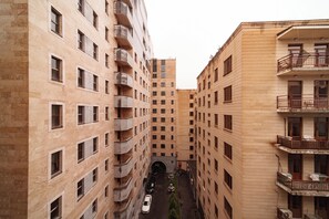 A multi-story residential building with balconies, a central courtyard, and a narrow street leading to a tunnel entrance. - Arch Apart Hotel (Yerevan)