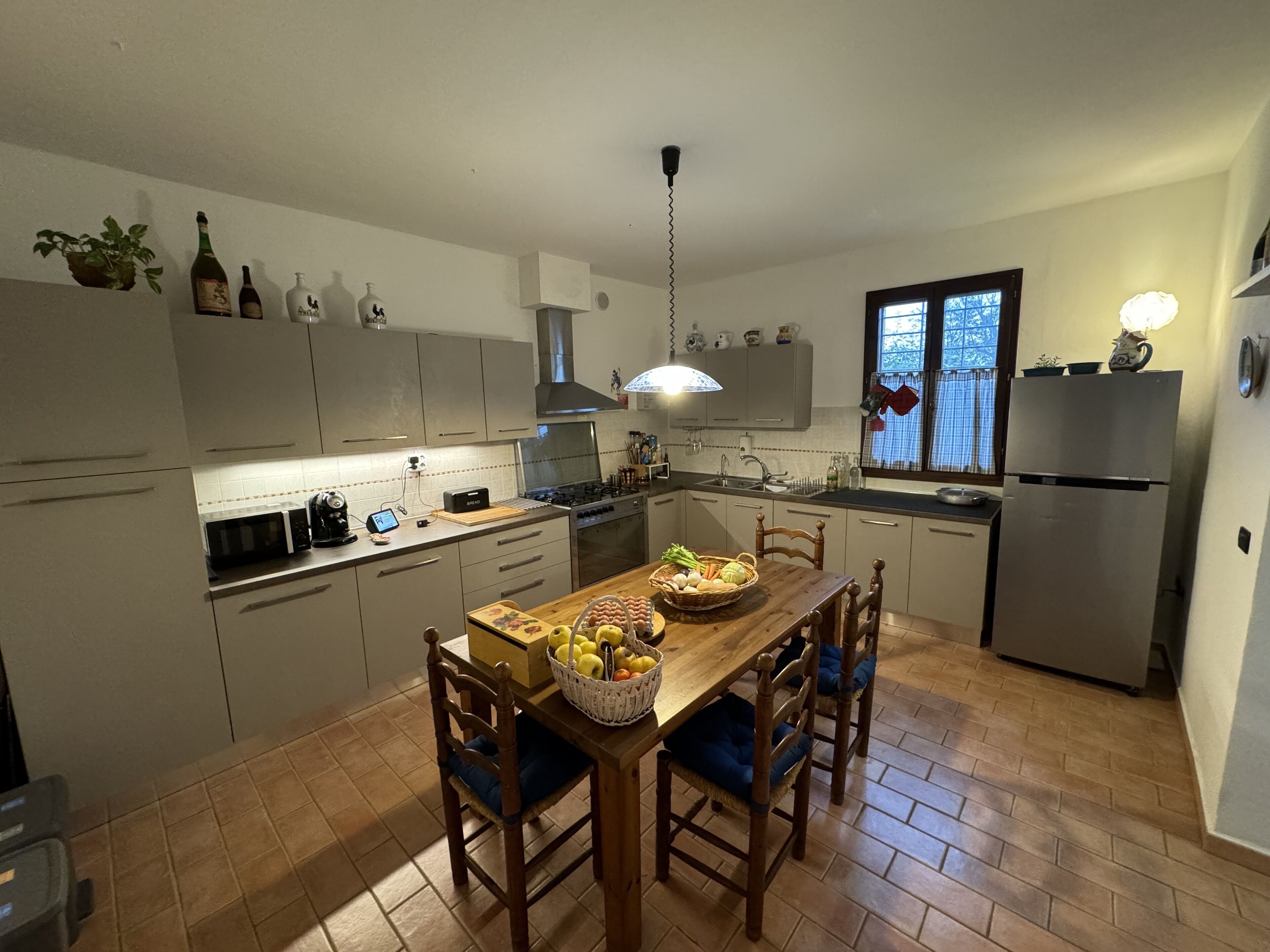 Una cocina moderna con armarios blancos, una mesa de comedor de madera y un horno empotrado.