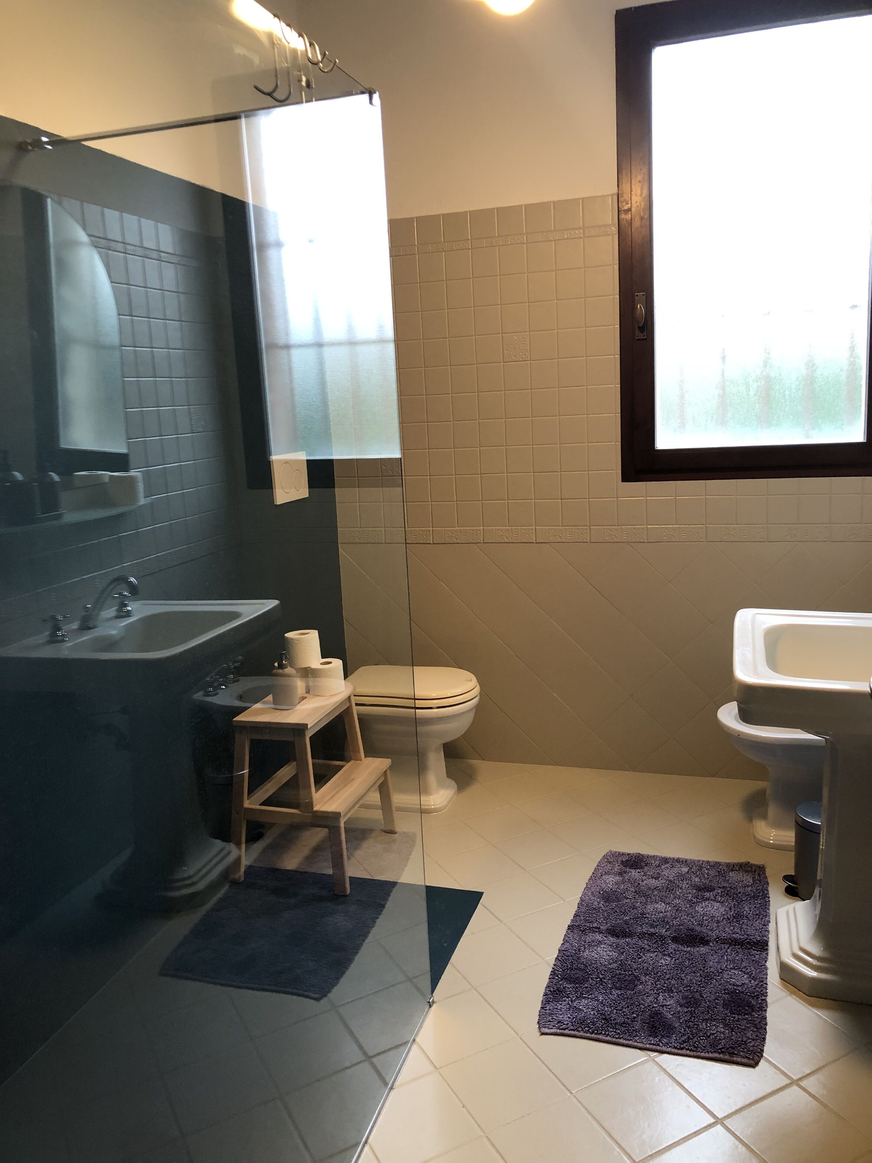 Une salle de bain avec une baignoire, des toilettes, un lavabo et une fenêtre.