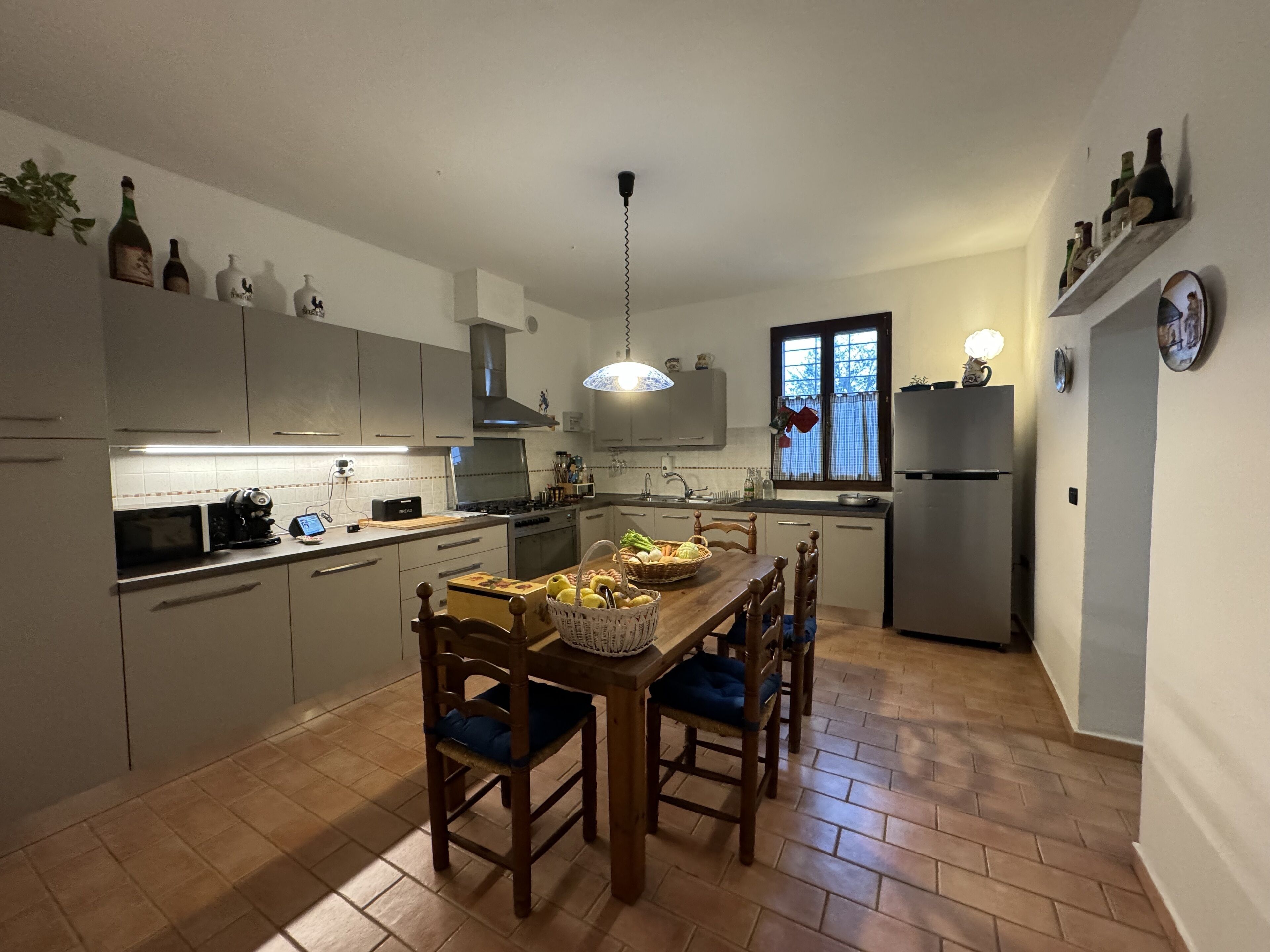 A modern kitchen with a dining table, chairs, and various kitchen appliances.