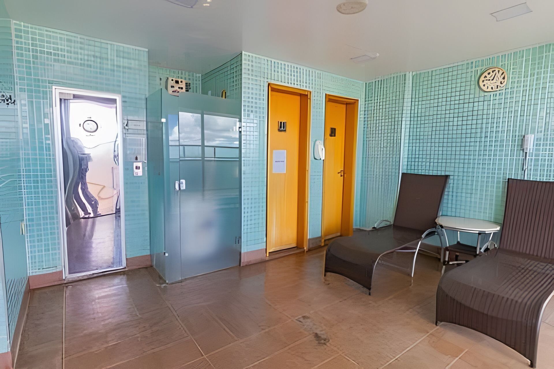 A hotel lobby with a tiled floor, a reception desk, and a seating area.