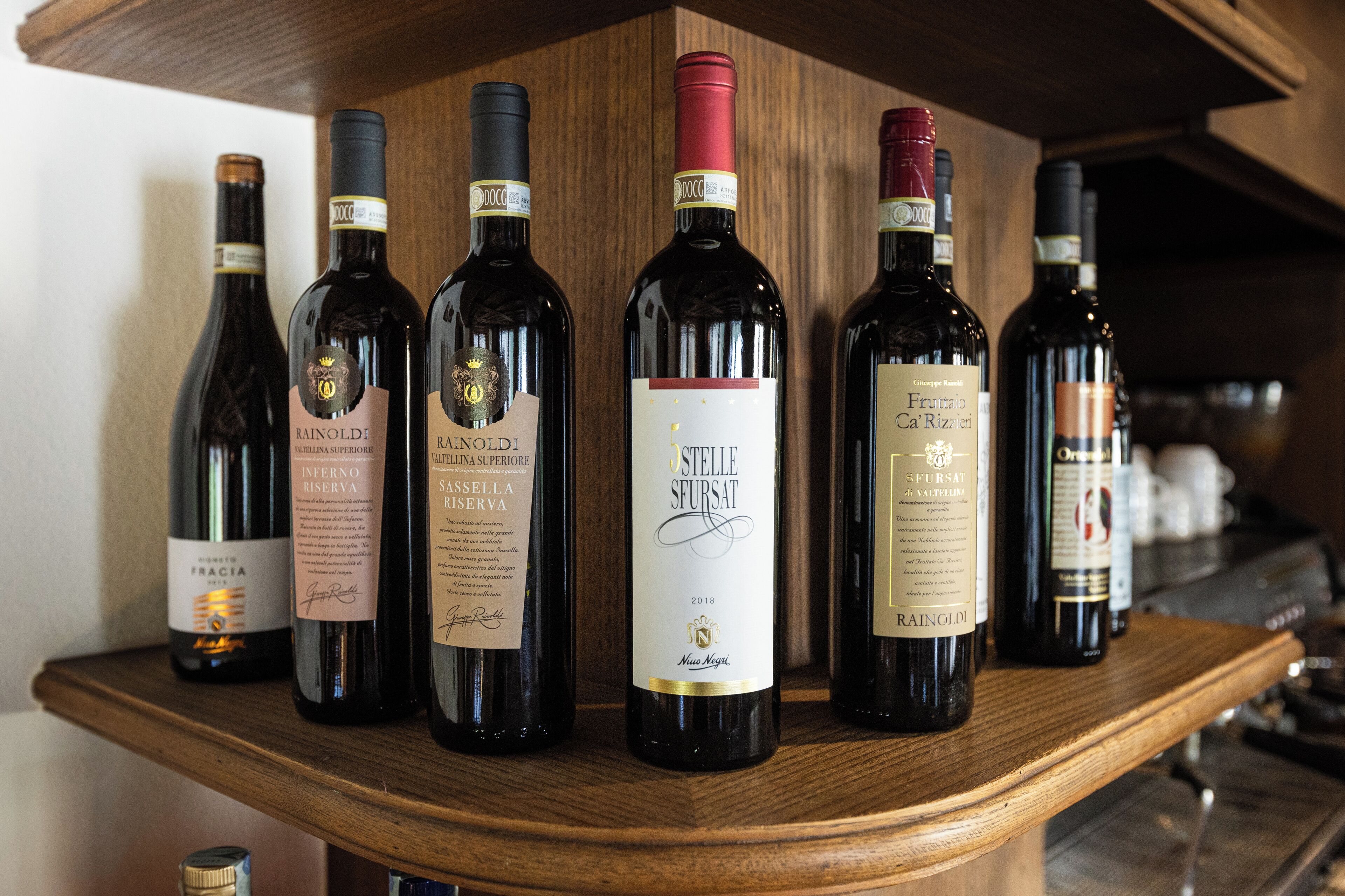 Varias botellas de vino sobre una estantería de madera.