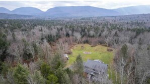 A house surrounded by a forest with a clear view of distant mountains. - Spacious 5 BR w/Mountaintop Views-2 Min to Hunter (Tannersville)