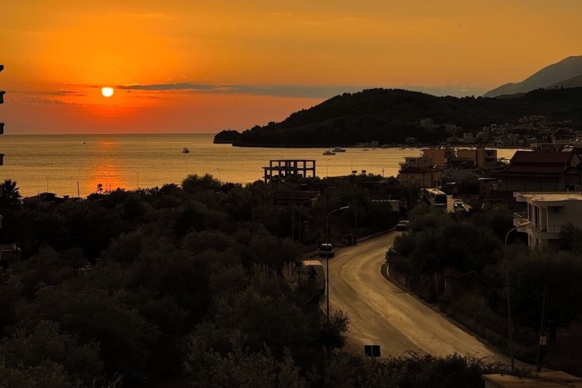 A coastal sunset view with a road leading to a small town.