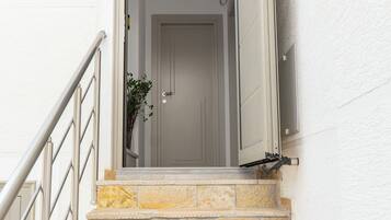 Una scala con gradini in pietra che conduce a una porta con cornice bianca.