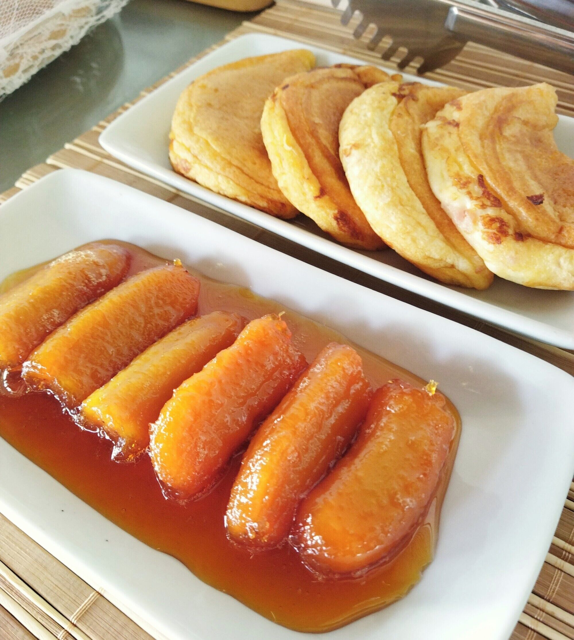 A plate of pancakes and a dish of glazed carrots.