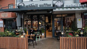 A coffee shop with outdoor seating and a sign reading "Mahall Coffee". - Mahall Hotel (Istanbul)