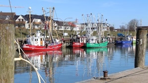 A harbor with several fishing boats docked. - Pension Nordwind (Hedwigenkoog)