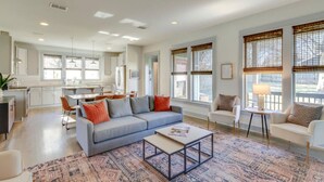 A spacious living room with a grey sofa, a coffee table, and a patterned rug. - Cleveland Park Charmer | Large Private Backyard (Nashville)