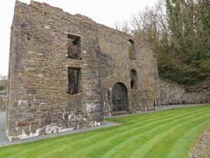 A historic stone building with arched windows and a metal gate. - 16 Heritage Park (Narberth)