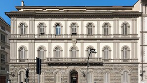 Un edificio storico con facciata simmetrica, ampie finestre ad arco e un ingresso centrale.