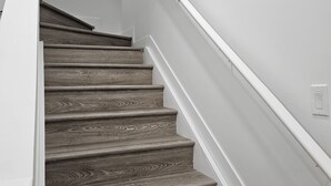Un escalier avec des marches en bois et des murs blancs.