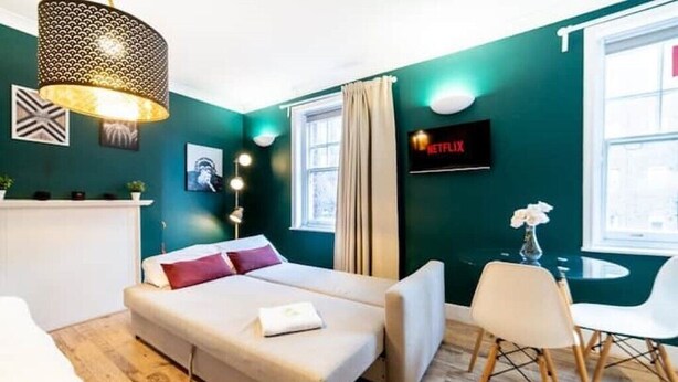 Une chambre moderne équipée d’un lit, d’une télévision et d’un coin repas.