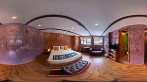 Een ronde kamer met een bed, houten vloeren en een muurschildering.