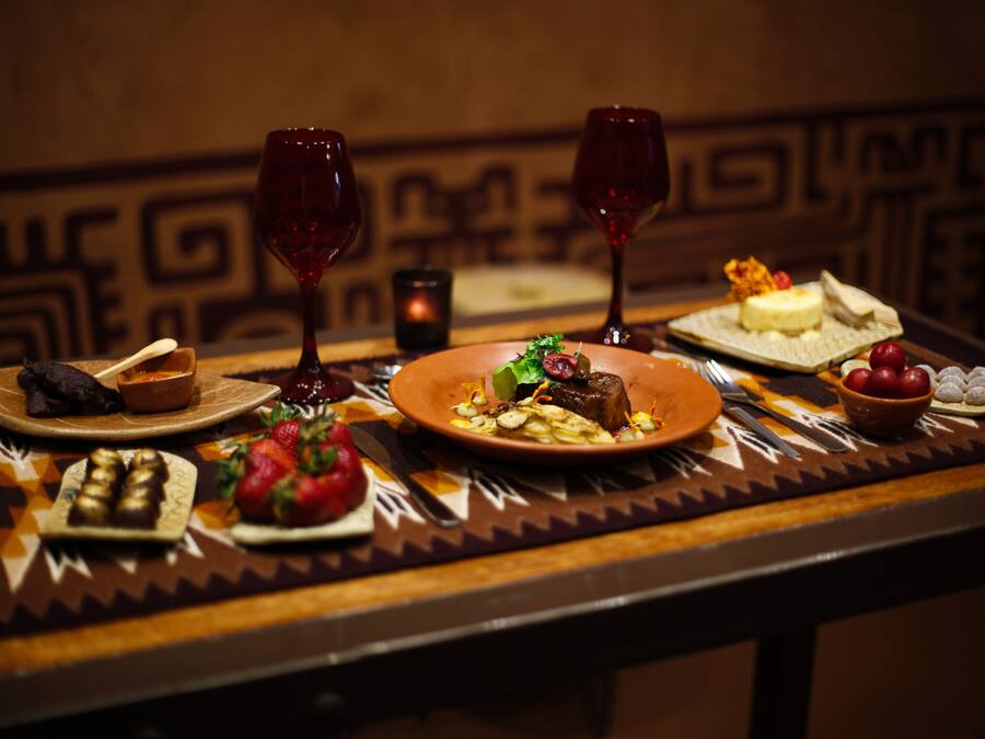 A dining table with various dishes, wine glasses, and cutlery.