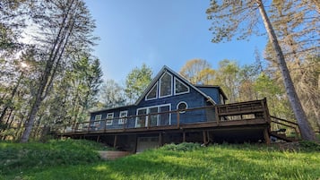 Situated in a forested area, this cabin-style building offers a view of the surrounding trees and landscape from its elevated position.