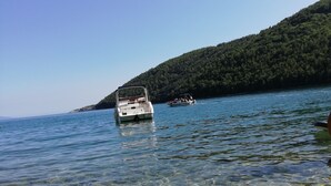 A boat on a clear lake with rocky shore and a forested hill in the background. - 2 Bed House - Sleeps 4 - Garden - Parking - Wifi (Rasa)
