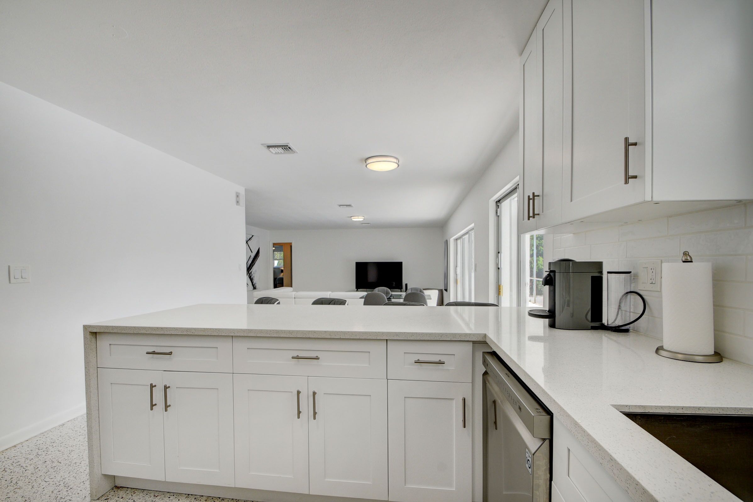 A modern kitchen with white cabinetry, a central island, and built-in appliances.