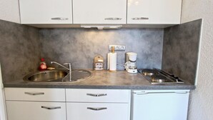 A compact kitchen with a sink, a coffee maker, and a small refrigerator. - 10m from ski slopes, 1st floor, balcony, tv, 22m², Chamrousse (Chamrousse)