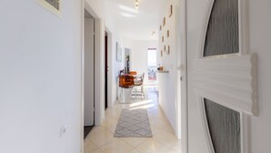A hallway with a tiled floor, a rug, and a door with a decorative panel. - Apartment mit Wunderschönem Meerblick nur 5 Minuten vom Strand Entfernt (Sveta Marina)