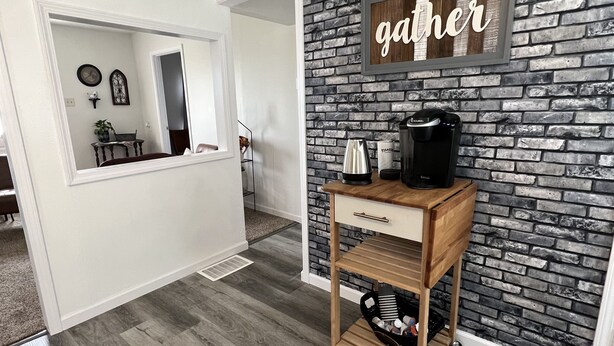 A room with a brick wall, a coffee machine, and a wooden cart. - Explore the Shawnee National Forest-reserve the SHAWNEE HIDEAWAY (Equality)