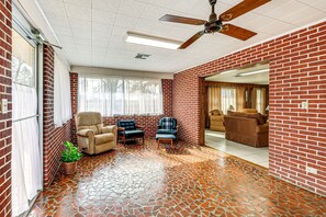 A room with a brick wall, a ceiling fan, and a tiled floor. - Countryside Marion Retreat Near Fishing & Trails! (Marion)