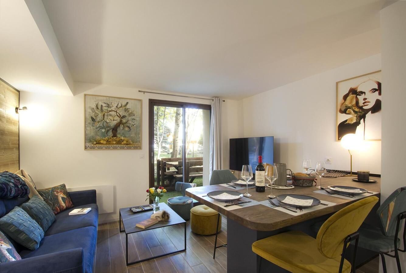 Ein modernes Wohnzimmer mit einer Couch, einem Couchtisch und einem Essbereich mit Tisch für zwei Personen.