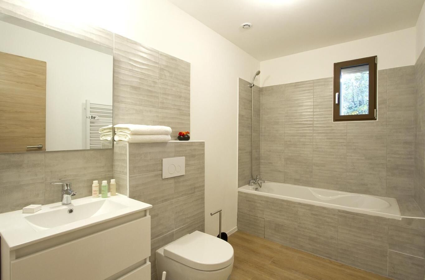 Une salle de bain moderne avec un lavabo, des toilettes et une baignoire.