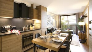 A modern kitchen with a dining area, wooden cabinetry, and a large window providing a view of the outdoors. - 300m from ski slopes, 2nd floor, balcony, tv, ski locker, 48m², Les 2 Alpes (Mont-de-Lans)