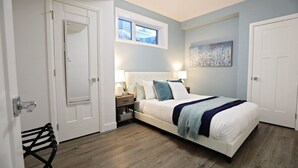 Een slaapkamer met een bed, nachtkastjes, een raam en een deur.