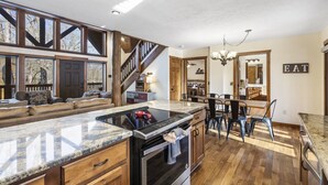 A spacious kitchen with a large island, wooden flooring, and a built-in oven. - Lodge Near SDC with 4 King Suites and Pools (Branson)