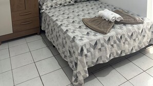 Un dormitorio con cama, armario y aire acondicionado.