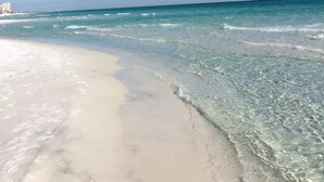A beach with clear water and a sandy shore.