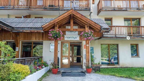 A wooden building with balconies and flower boxes in front. - 200m from ski slopes, 1st floor, view valley/exceptional, swimming pool, balcony, tv, ski locker (Les Orres)
