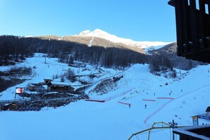 A snow-covered mountain with a ski resort, including ski lifts and a lodge.