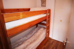 A bunk bed with a wooden frame and a white mattress.