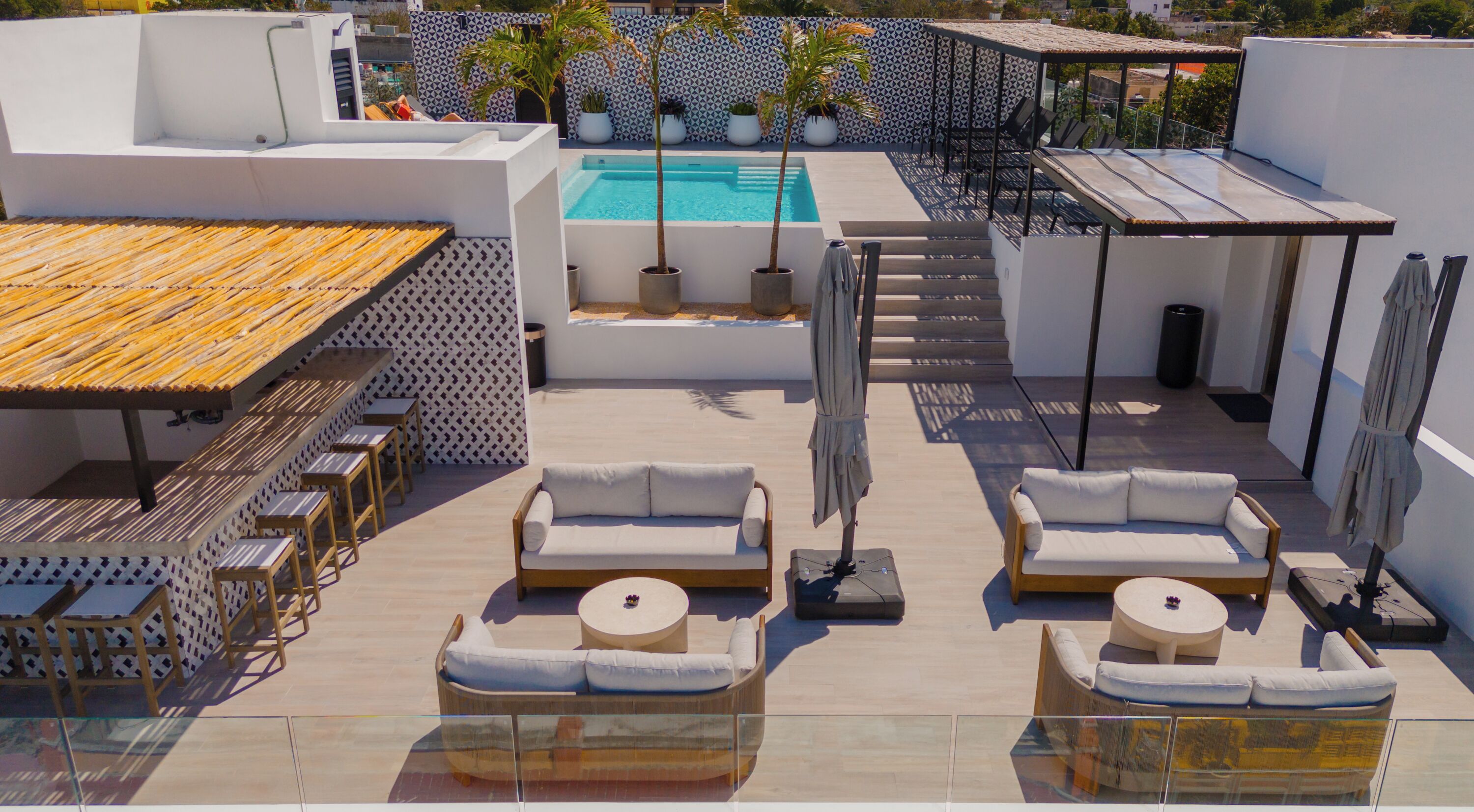A rooftop terrace with a swimming pool, sun loungers, and a dining area.
