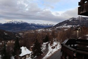 A mountainous landscape with snow-covered peaks and a valley below.