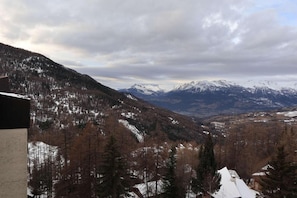 A mountainous landscape with snow-covered peaks and a valley.