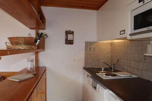 A compact kitchen with a wooden countertop, a built-in microwave, and a tiled backsplash. - 40m from ski slopes, 3rd floor, balcony, 40m², Les Orres (Les Orres)
