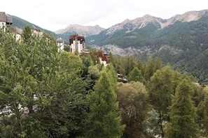 Eine gebirgige Landschaft mit einem Gebäude, umgeben von dichtem Wald.