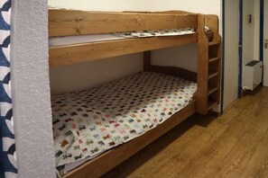 A bunk bed with a patterned mattress and a wooden frame.