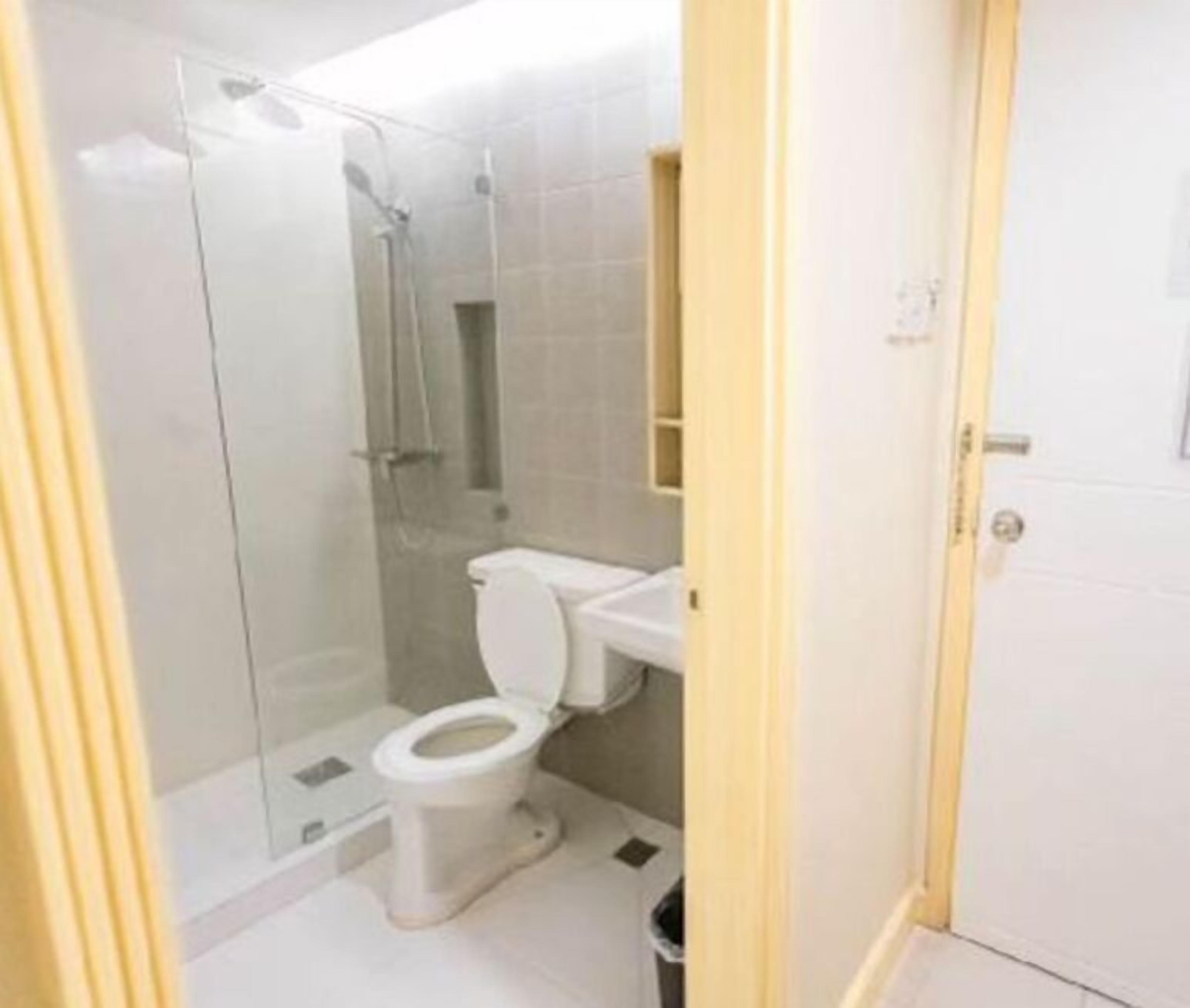 A small bathroom with a toilet, a shower, and a sink.