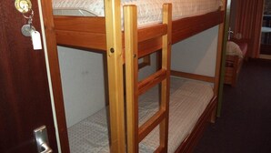 A bunk bed with a wooden frame and a mattress.