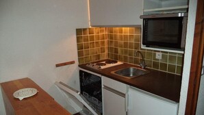 A compact kitchen with a built-in oven, a dishwasher, and a sink.