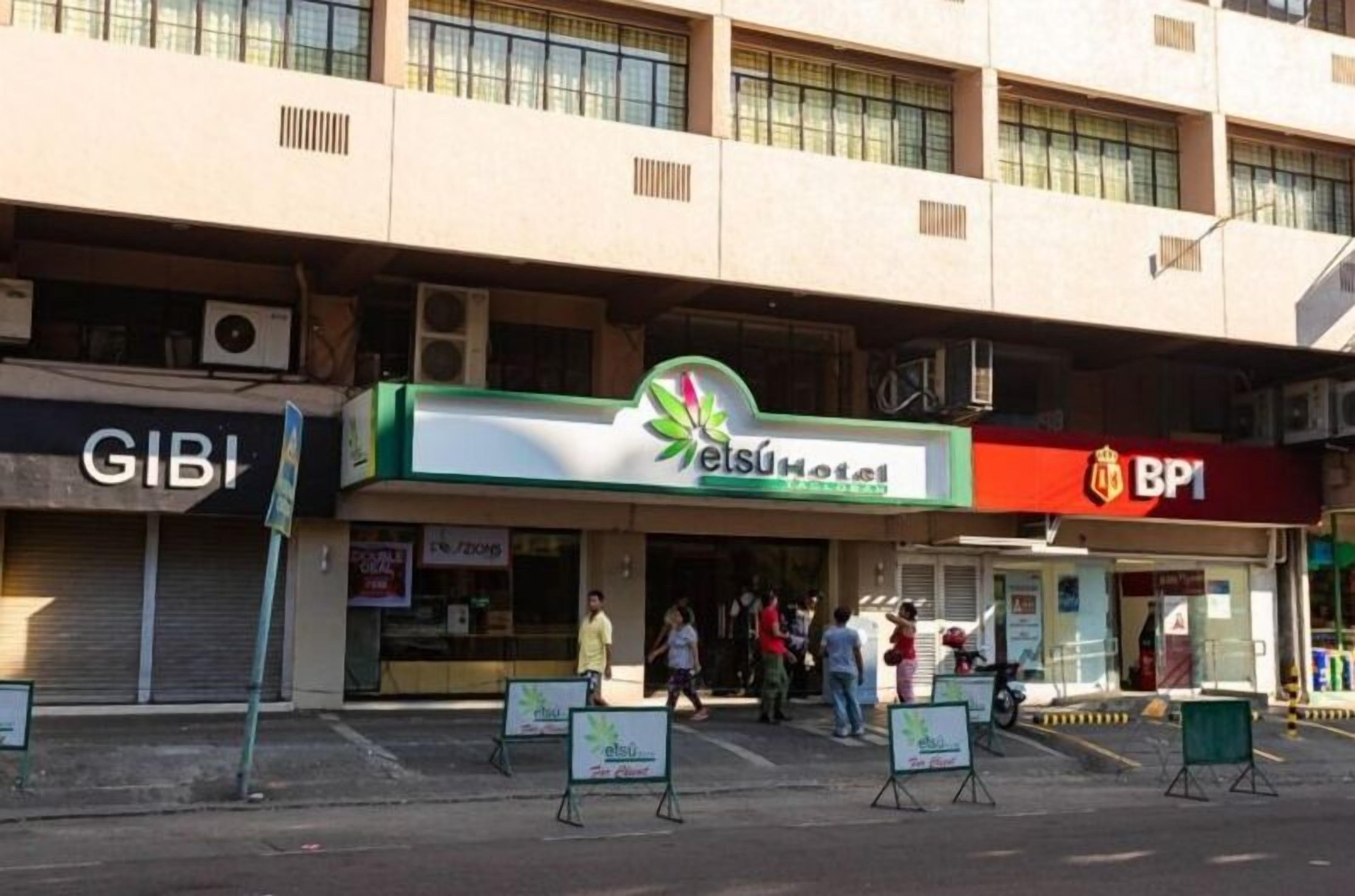 A hotel with a green and white sign, a BP1 gas station, and a closed GIBI store.